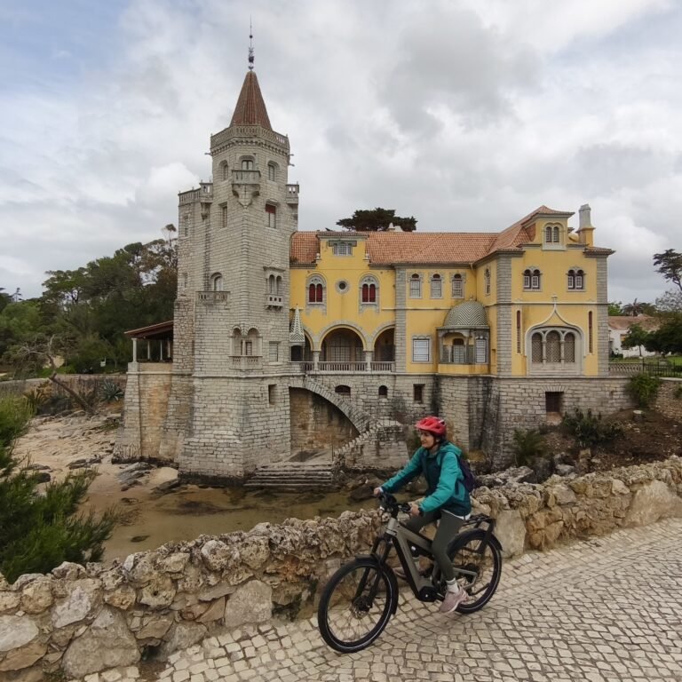Cyclist riding in front of a historic building in Cascais, Portugal.