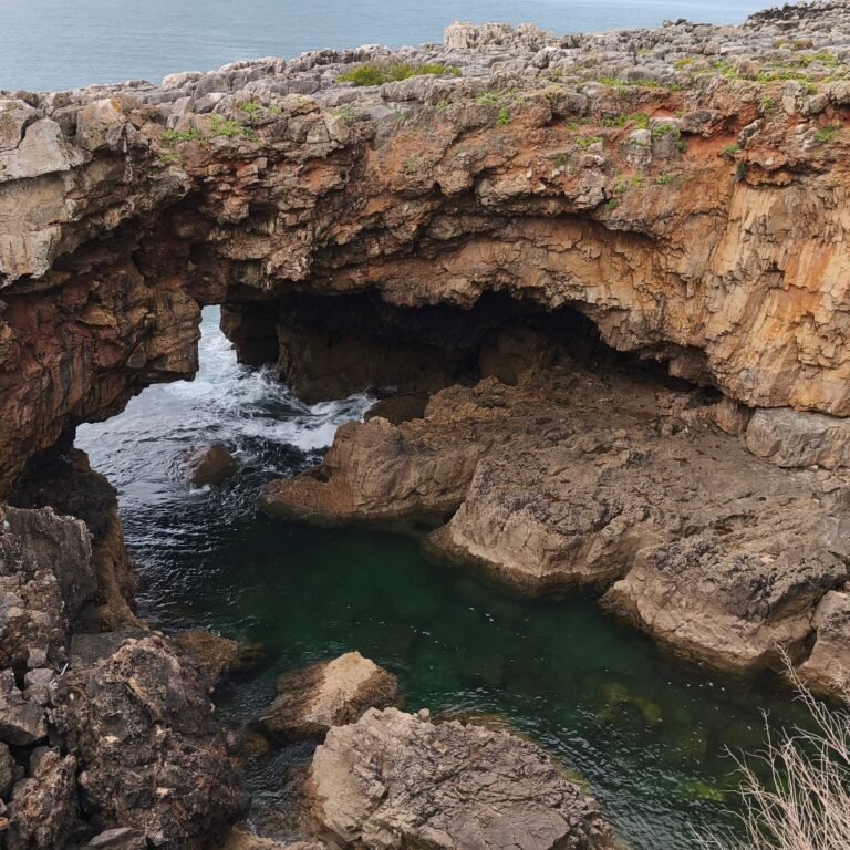 Natural rock formation with sea caves and coastal pools in Cascais.