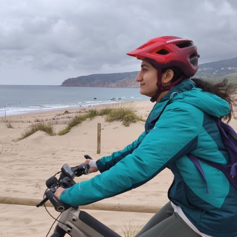 Female cyclist pausing to admire the beautiful coastal view in Cascais.
