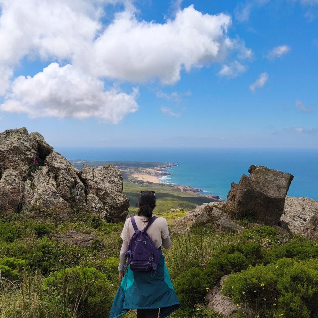 Hiker overlooking the Atlantic Ocean and dramatic cliffs from the Serra de Sintra trails.