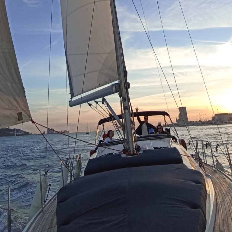 View from the front of a sailboat looking towards the bow and river in Lisbon