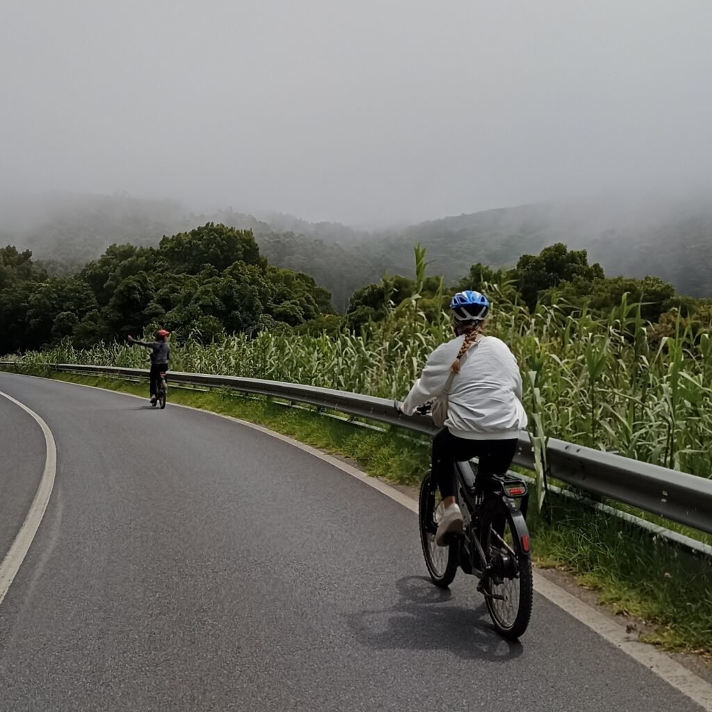 Cyclists riding uphill with views of the ocean on the Cascais Bike Ride.