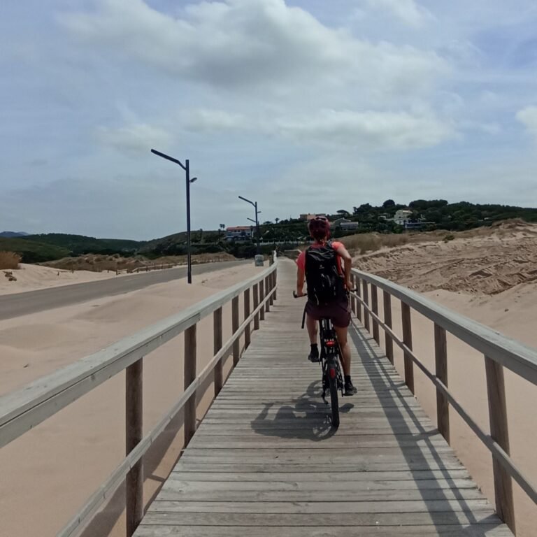 Cyclists crossing a wooden bridge on a nature trail in Cascais.
