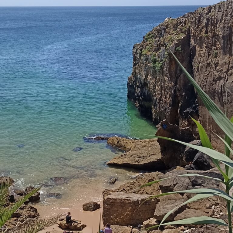 Bikes parked by the seaside with rocky cliffs in the background in Cascais.