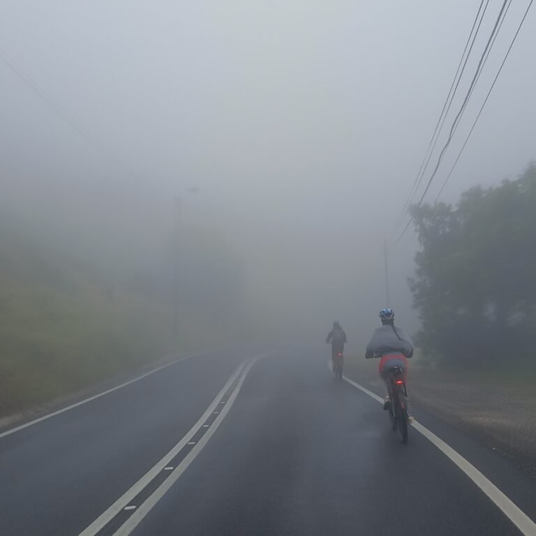 Cyclist riding on a foggy rural road in the Cascais countryside.