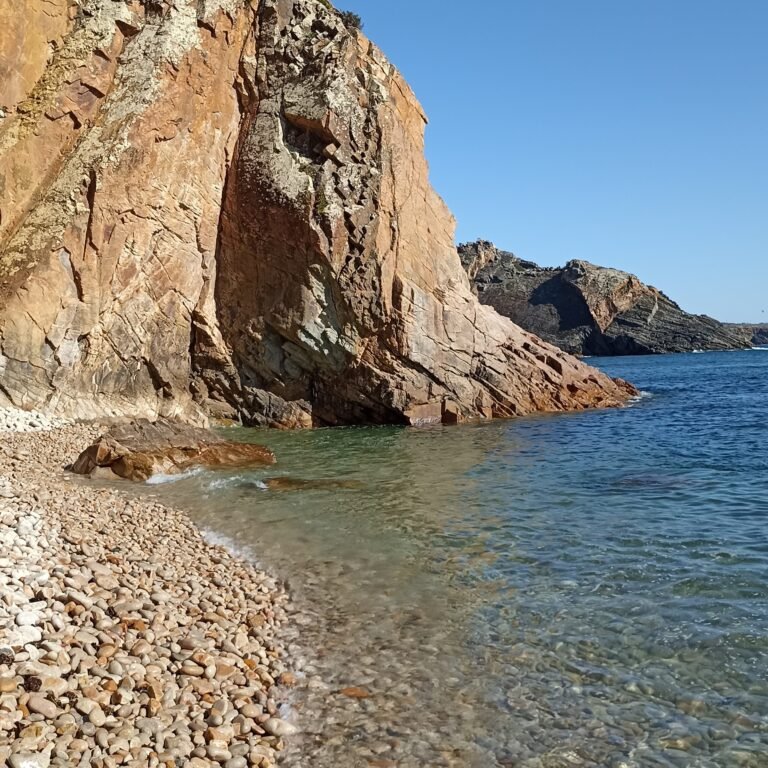 Sea stacks and clear blue waters along the picturesque Cascais coastline.