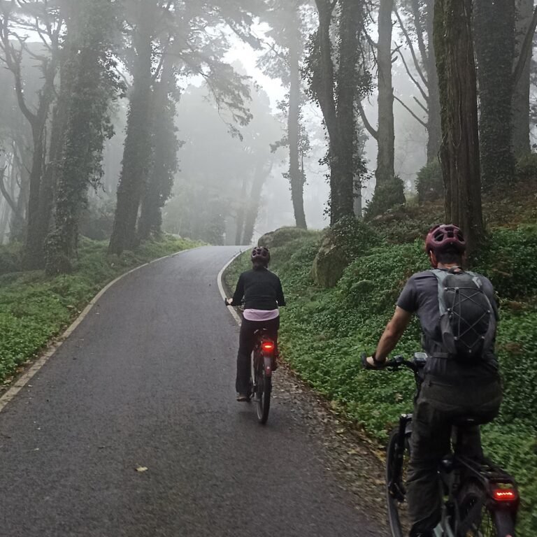 Group of cyclists riding together on a rural road in Cascais.