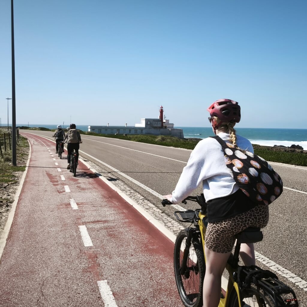 Cyclist riding on the seaside bike lane with stunning views of Praia do Guincho.