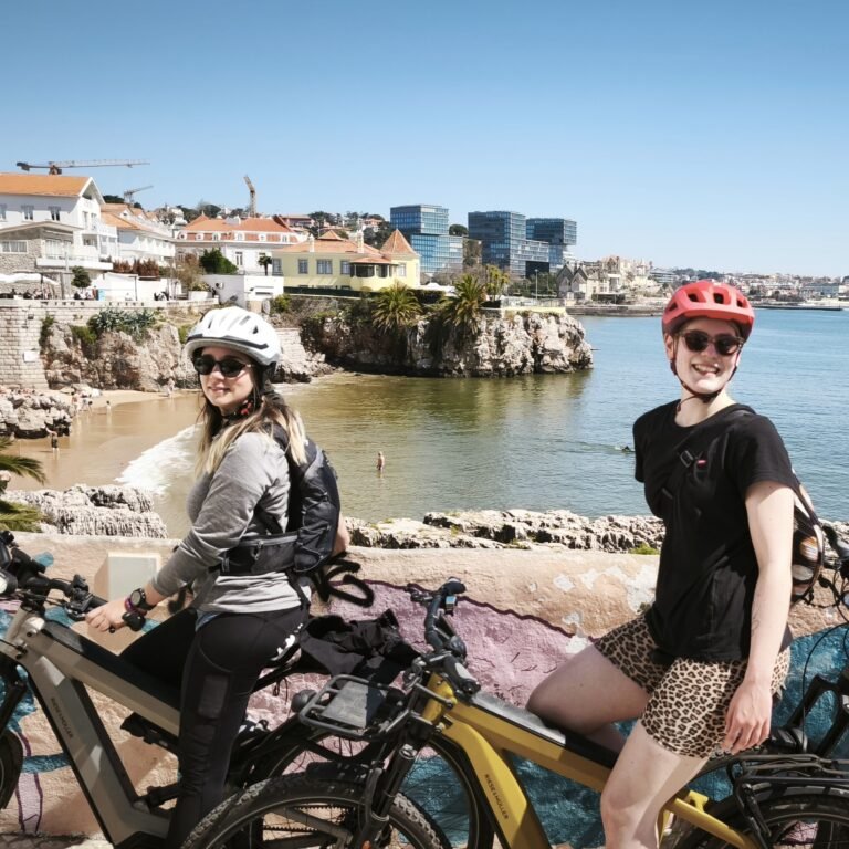 Cyclist riding on a coastal bike path with panoramic ocean view in Cascais.