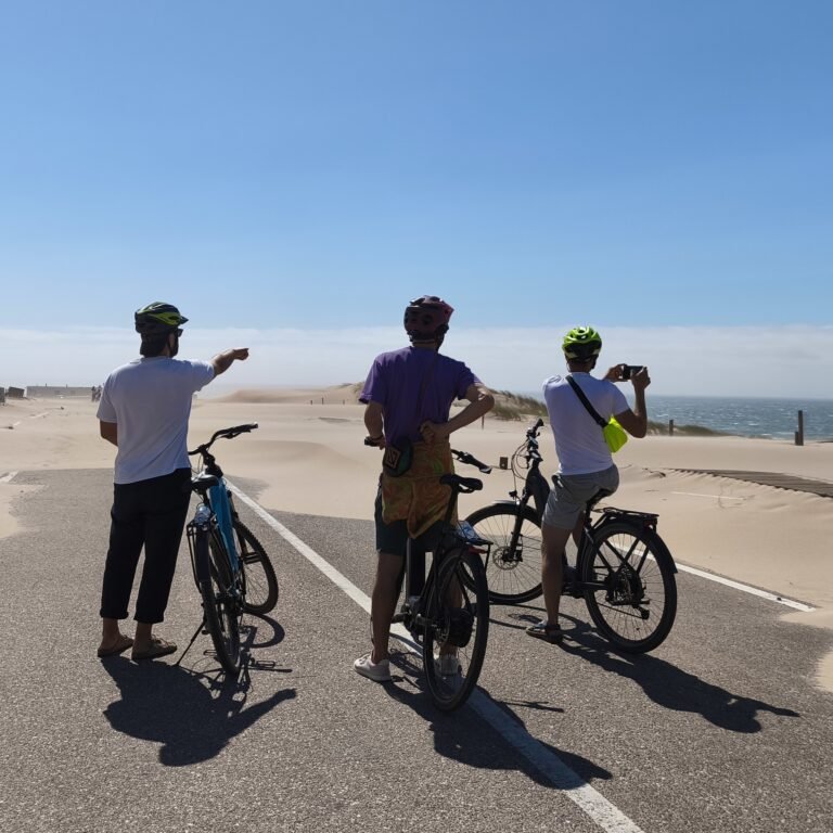 Cyclist riding on an asphalt road through natural surroundings in Cascais.