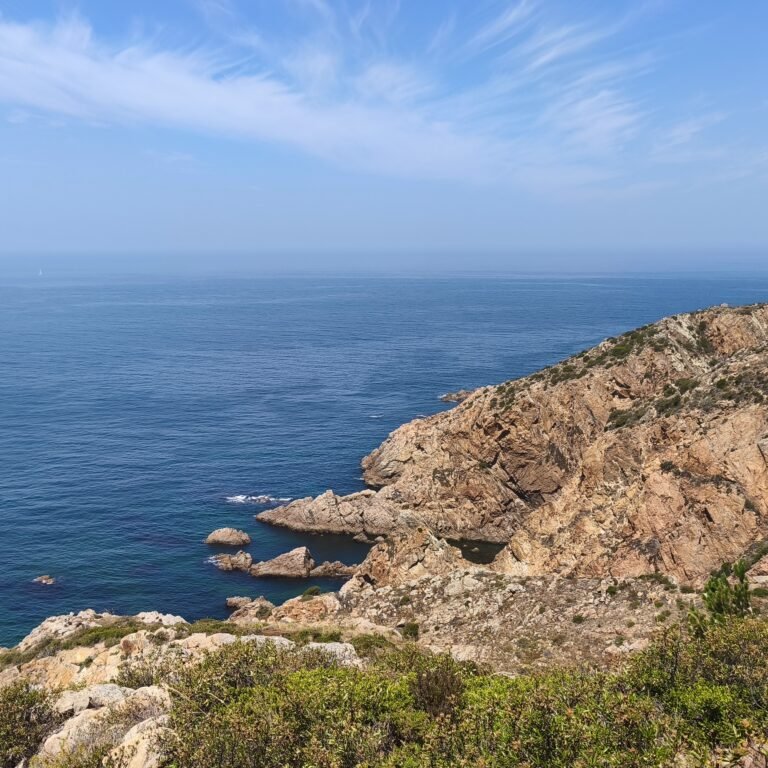 Group of hikers walking along the cliffs of Sintra-Cascais Natural Park.