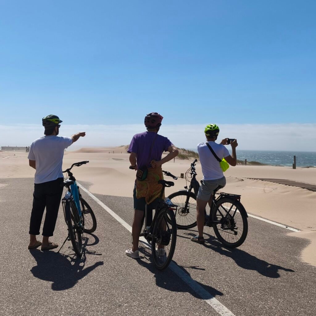 Cyclists riding uphill with views of the ocean on the Cascais Bike Ride.