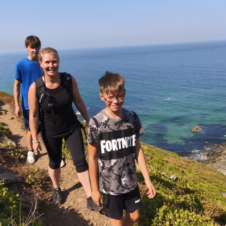 Group walking by the rugged Atlantic coast between Praia do Abano and Cabo da Roca on the Atlantic Wild Hike.
