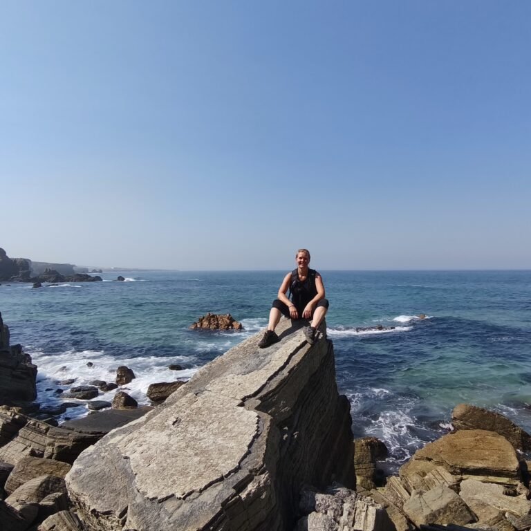 Hiker admiring Atlantic Ocean views from the cliffs on the Atlantic Wild Hike.