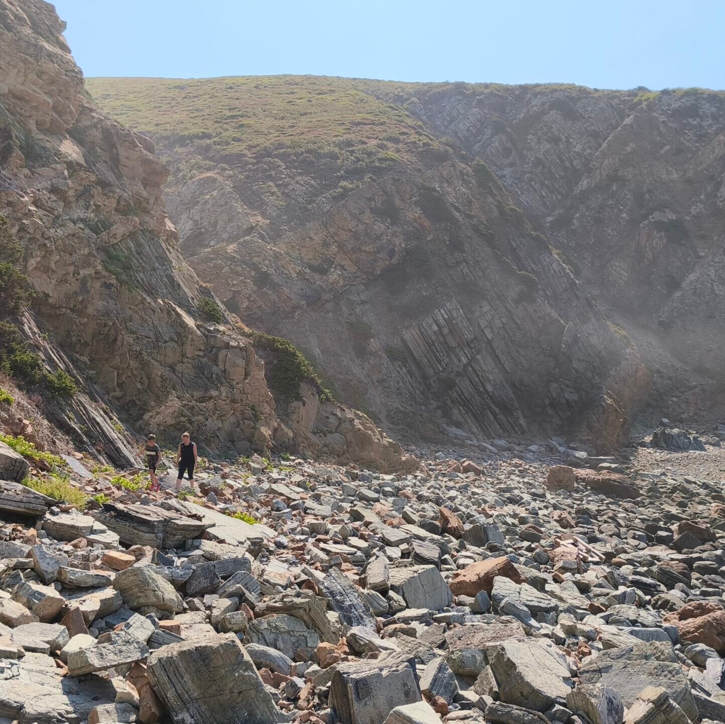 A steep path made of loose rocks leading down to a hidden beach in Cascais.